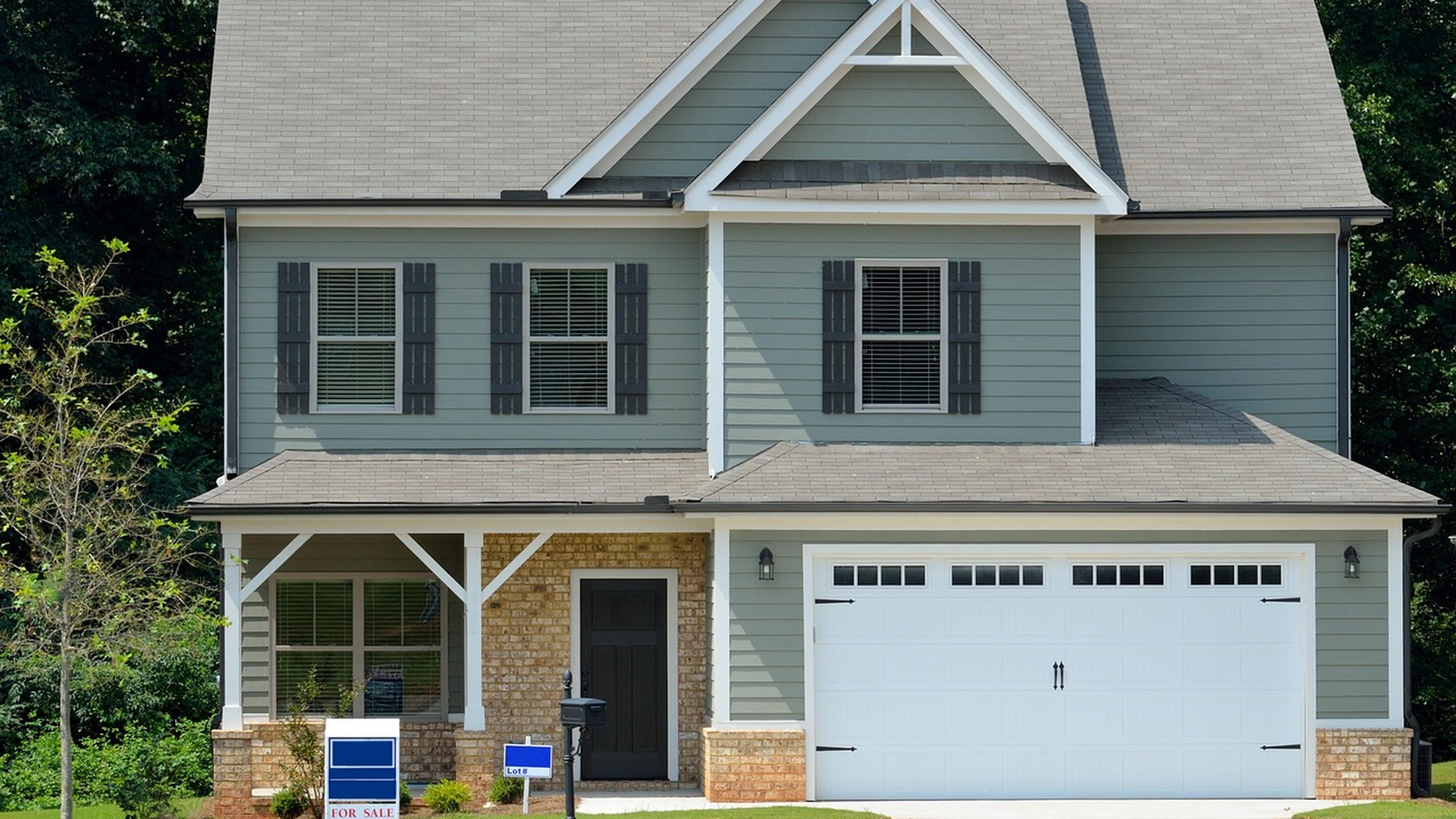 Two-story suburban home with for-sale signs in the front yard, the kind of property that gets a seller at home inspection