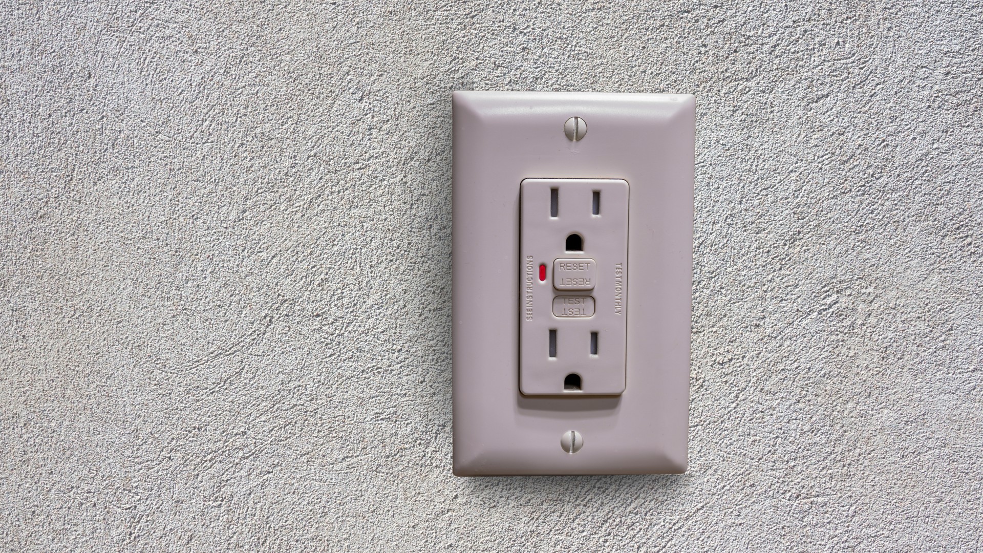 Close-up of a white GFCI outlet with test and reset buttons installed in a residential kitchen wall, showing the type of receptacle a home inspector checks during a Pennsylvania home inspection.