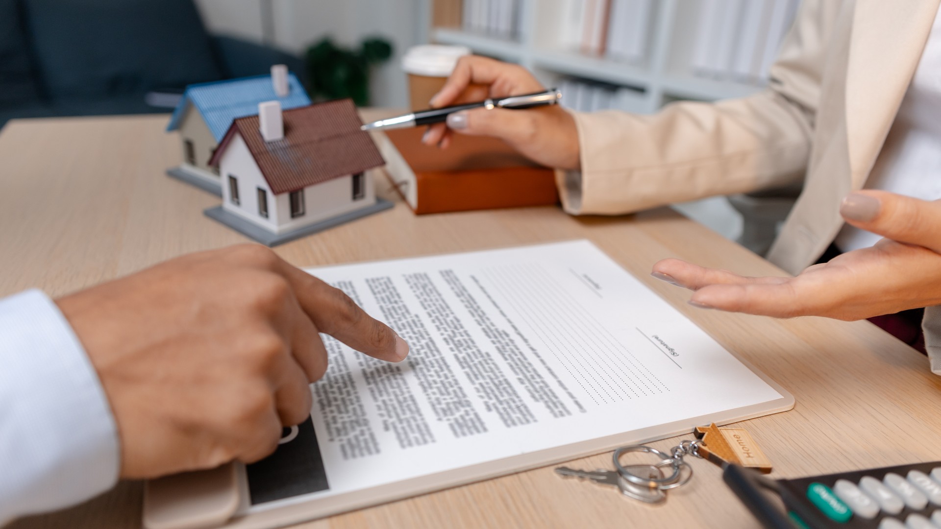 Pennsylvania real-estate agent and homebuyer reviewing a home purchase contract and inspection-related paperwork at an office table.